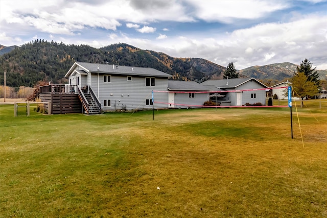 exterior space with a deck with mountain view and a yard