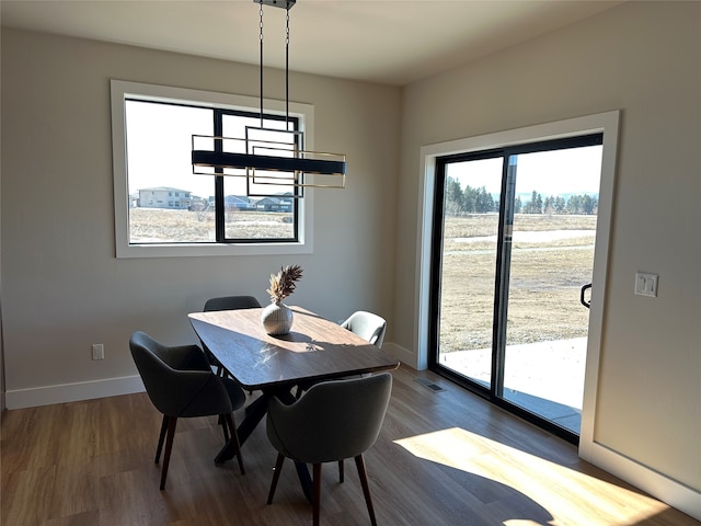 dining space with visible vents, baseboards, and dark wood-style flooring