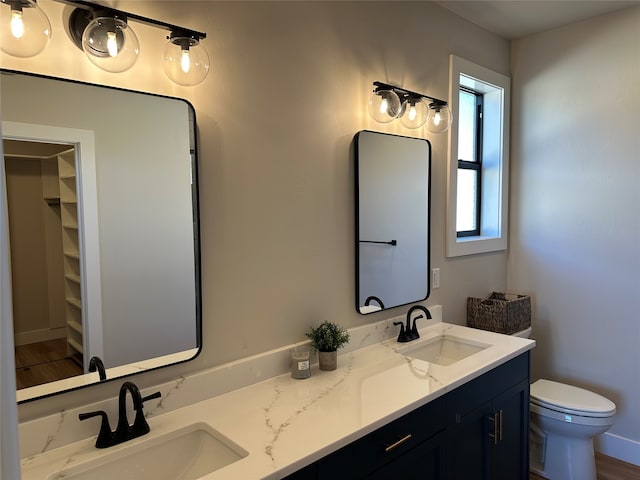 179 E Monture Rdg, Kalispell, MT 59901 - bathroom featuring double vanity, a walk in closet, and wood finished floors