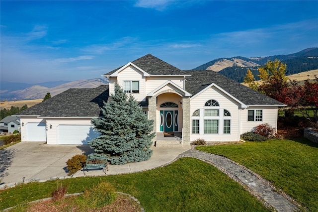 view of front facade featuring a front lawn, a garage, and a mountain view