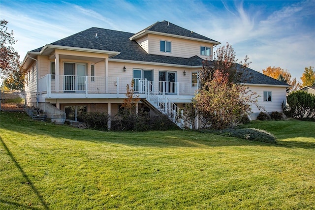 back of property featuring a wooden deck and a lawn