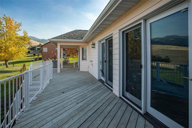 wooden terrace with a lawn and a mountain view