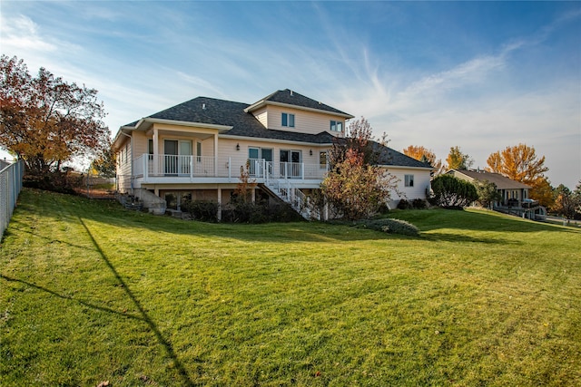 rear view of house with a lawn and a wooden deck