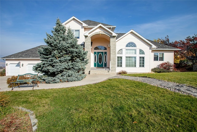 view of front of house with a garage and a front lawn