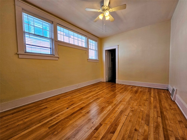 empty room with hardwood / wood-style flooring and ceiling fan