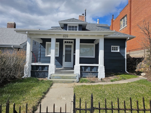 bungalow-style house with a front yard and covered porch