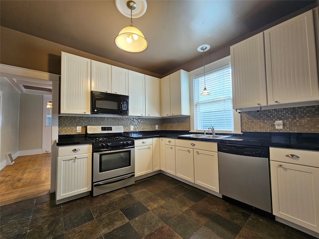 kitchen featuring stainless steel appliances, sink, decorative light fixtures, and decorative backsplash