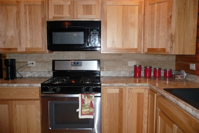 kitchen with sink, backsplash, stainless steel range with gas cooktop, and light stone countertops