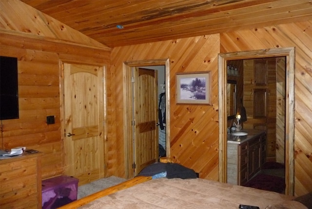 interior space featuring wood walls, wood ceiling, sink, and lofted ceiling