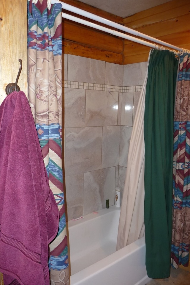 bathroom featuring wooden walls and shower / bathtub combination with curtain