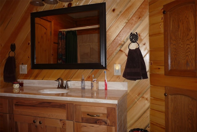 bathroom featuring vanity and wooden walls