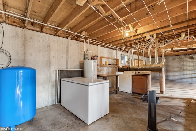 basement with washer and clothes dryer, white refrigerator, and water heater