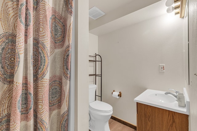 bathroom featuring wood-type flooring, toilet, and vanity