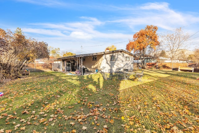 back of property featuring a patio and a yard