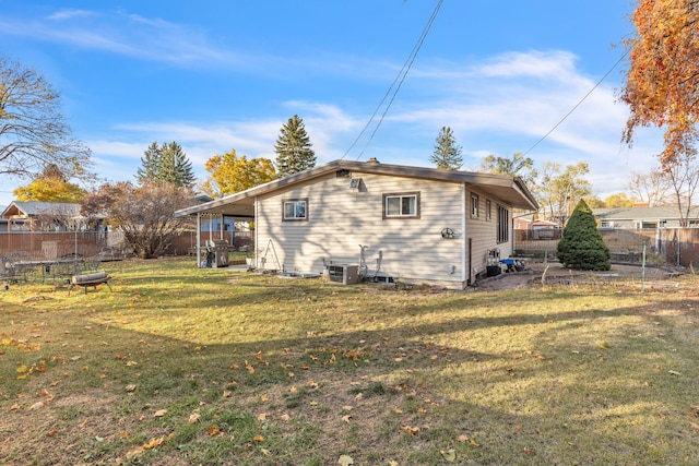 back of property featuring central AC unit and a yard