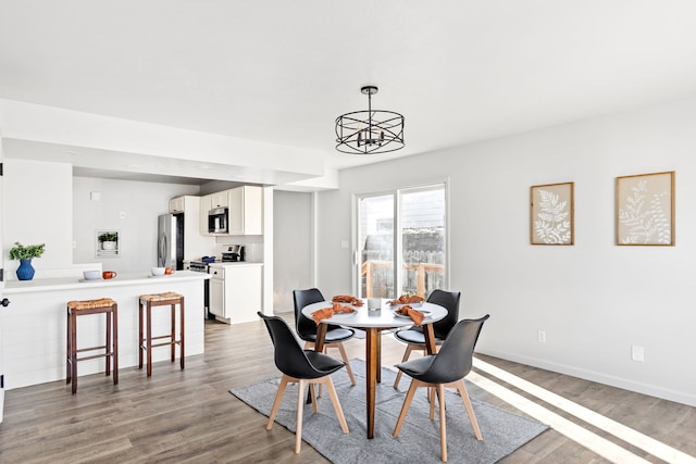 dining area featuring dark wood-type flooring and a chandelier