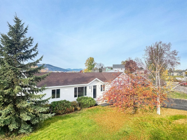 exterior space featuring a lawn and a mountain view