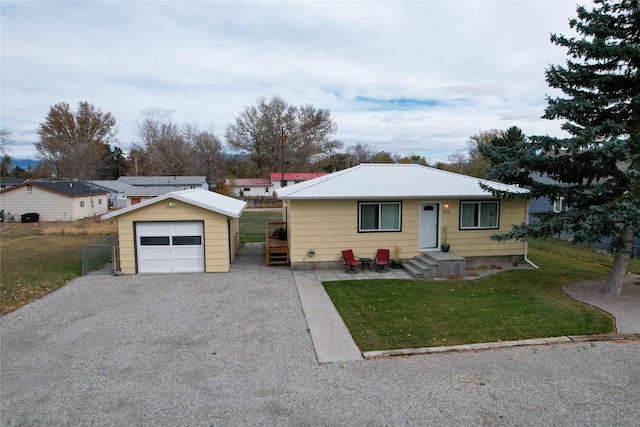 310 N Walnut St, Townsend, MT 59644 - view of front of house featuring an outdoor structure, gravel driveway, a front yard, a detached garage, and a metal roof