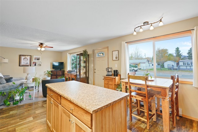 310 N Walnut St, Townsend, MT 59644 - kitchen featuring a ceiling fan, light wood-style flooring, light countertops, a kitchen island, and open floor plan