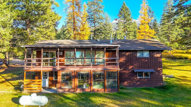 rear view of property with a balcony and a yard