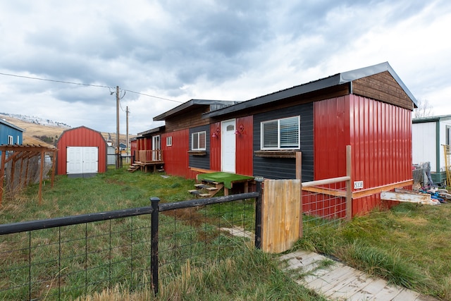 view of side of home featuring a yard and a storage shed