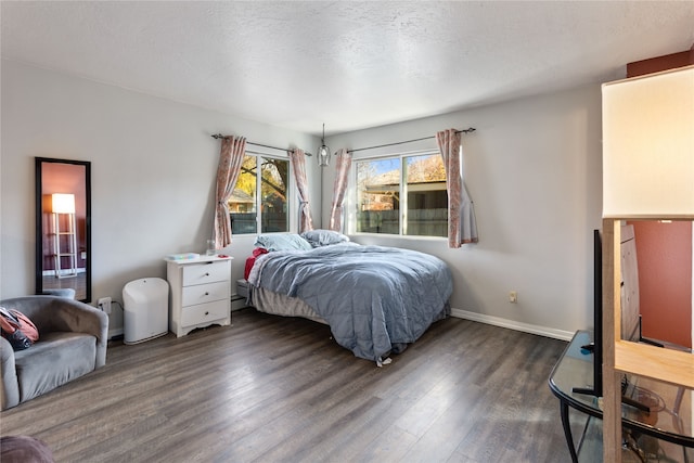 bedroom with a textured ceiling and dark hardwood / wood-style floors