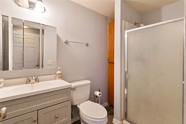 bathroom with toilet, an enclosed shower, and vanity