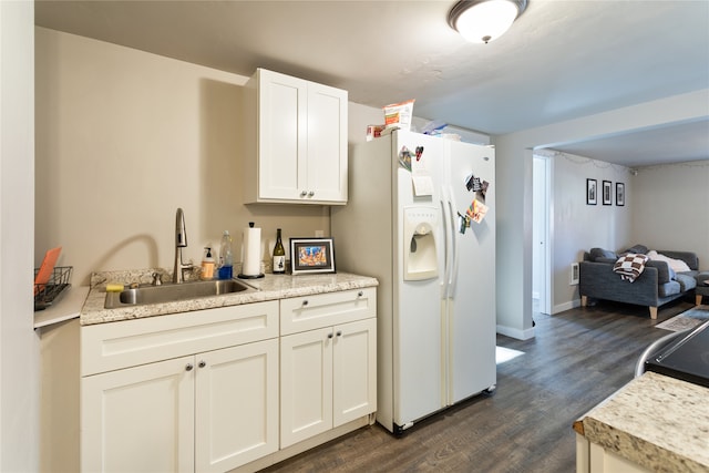 kitchen featuring sink, dark hardwood / wood-style flooring, white fridge with ice dispenser, and white cabinets