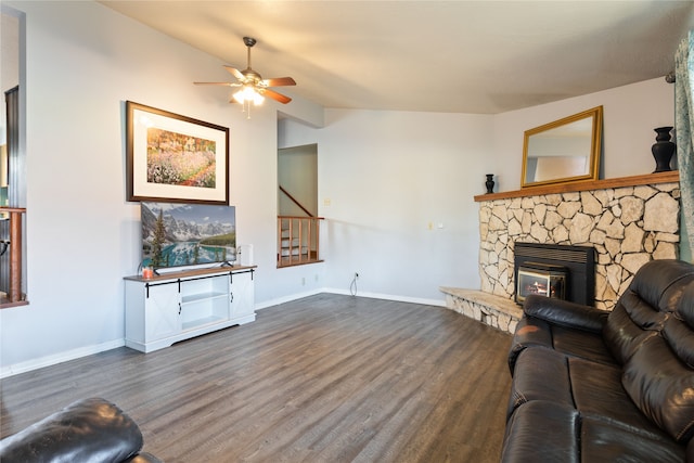 living room featuring a fireplace, ceiling fan, vaulted ceiling, and dark wood-type flooring