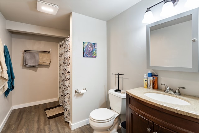 bathroom featuring toilet, vanity, and hardwood / wood-style flooring