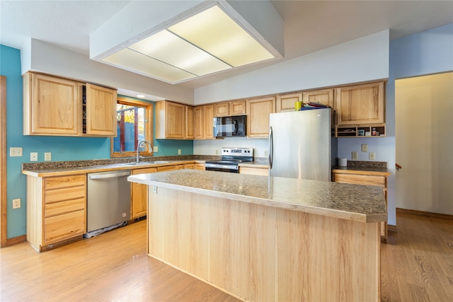 kitchen with a kitchen island, stainless steel appliances, light hardwood / wood-style floors, and sink