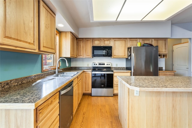 kitchen with a center island, appliances with stainless steel finishes, light hardwood / wood-style flooring, and sink