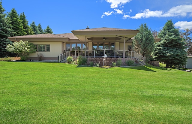 back of house with ceiling fan and a lawn