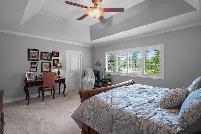 carpeted bedroom featuring a tray ceiling, ceiling fan, and crown molding