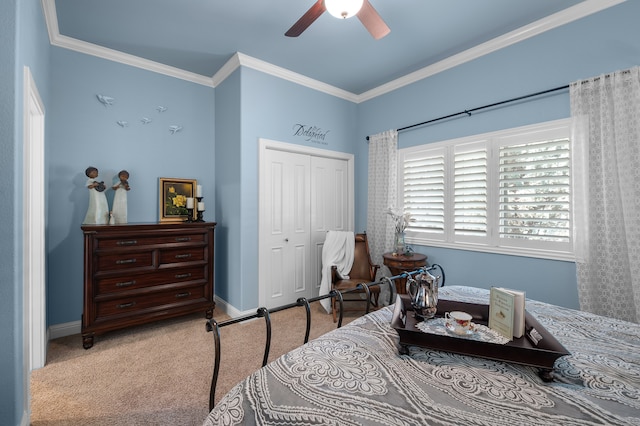 carpeted bedroom with a closet, ceiling fan, and crown molding