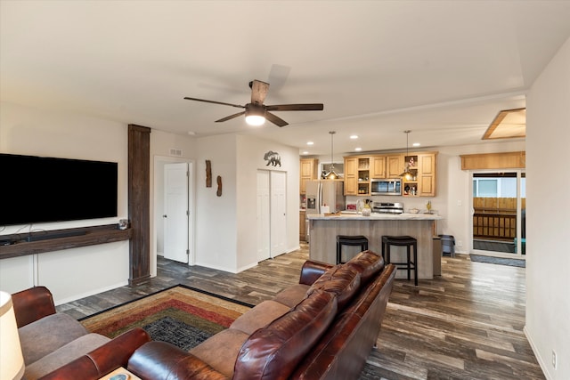 living room featuring dark hardwood / wood-style flooring and ceiling fan