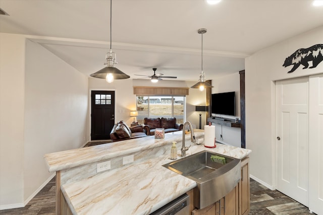 kitchen featuring a center island with sink, sink, ceiling fan, hanging light fixtures, and dark wood-type flooring