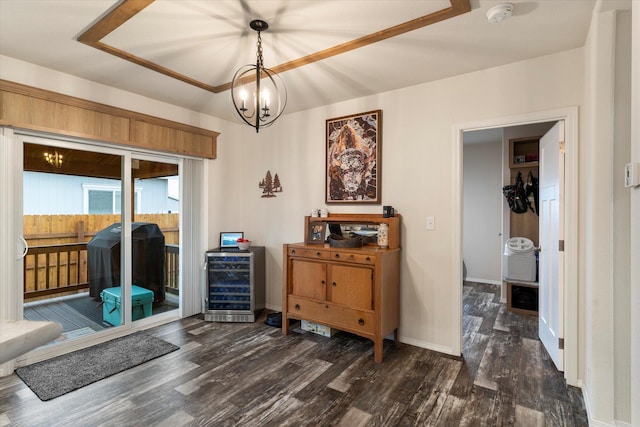 dining area featuring wine cooler, wood finished floors, a chandelier, and baseboards