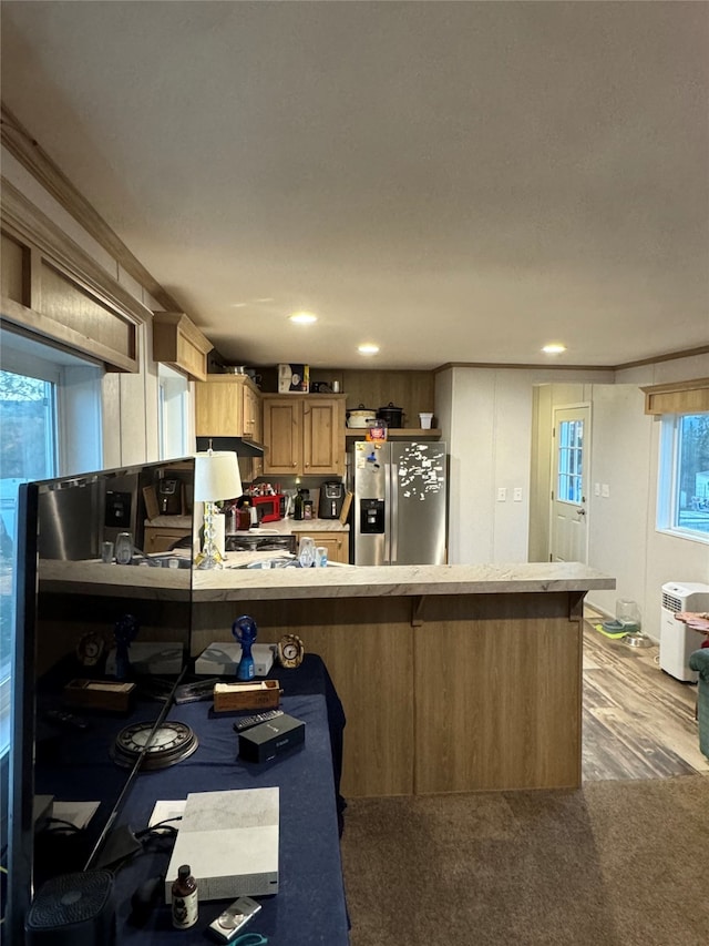 kitchen with carpet flooring, kitchen peninsula, white range oven, and stainless steel fridge with ice dispenser