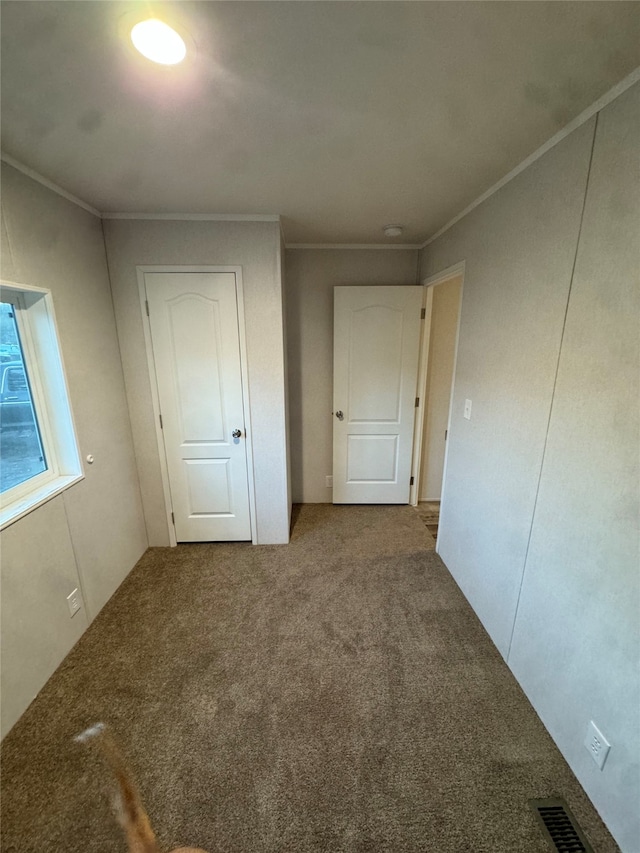 unfurnished bedroom with crown molding and carpet