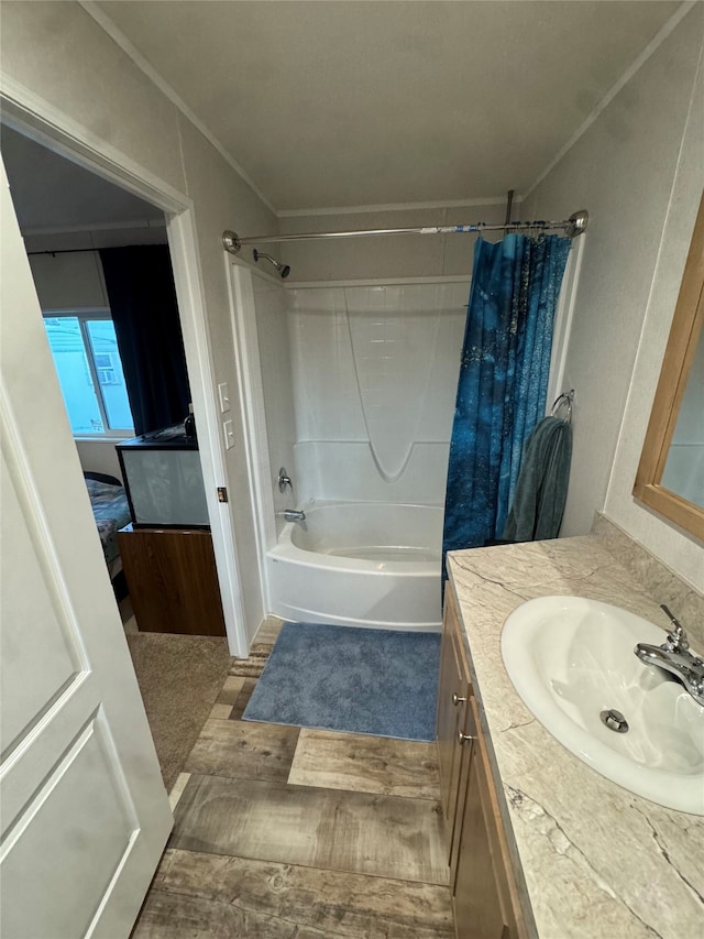 bathroom featuring hardwood / wood-style floors, vanity, shower / bathtub combination with curtain, and crown molding