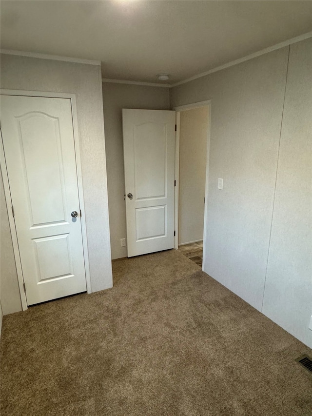 unfurnished bedroom featuring ornamental molding and carpet floors