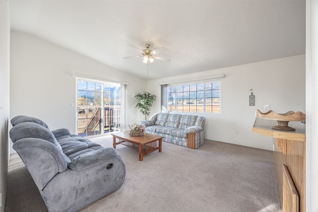 living room with a wealth of natural light, vaulted ceiling, and carpet floors