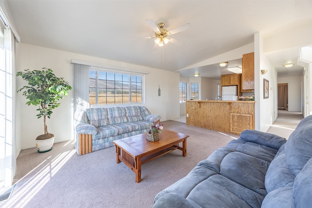 living room featuring ceiling fan, light carpet, and lofted ceiling