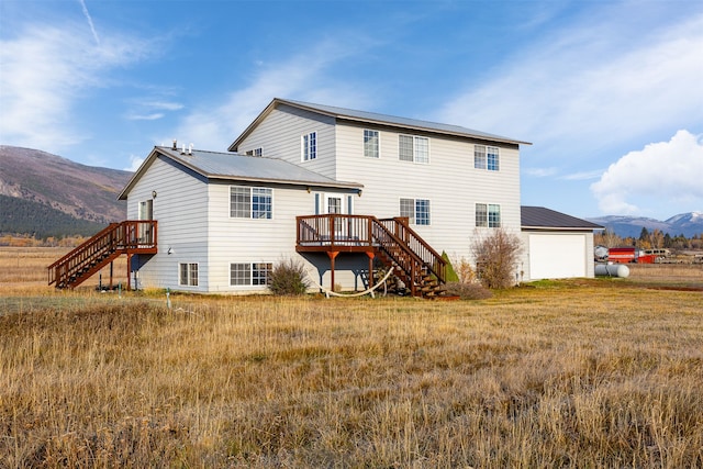 back of property featuring a garage and a deck with mountain view