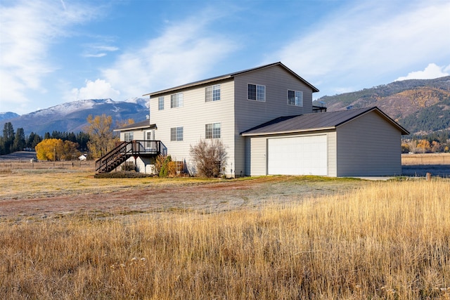 back of property featuring a garage and a deck with mountain view