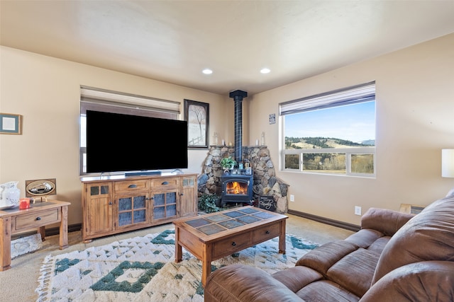 living room with a wood stove and light colored carpet