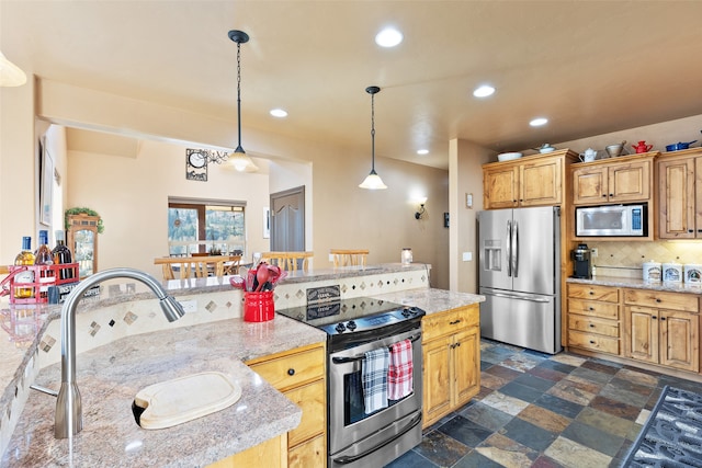 kitchen featuring light stone counters, stainless steel appliances, pendant lighting, decorative backsplash, and sink