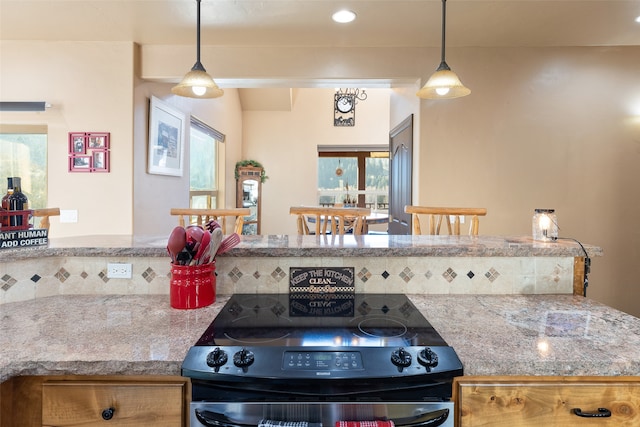 kitchen with plenty of natural light, decorative light fixtures, and black range oven