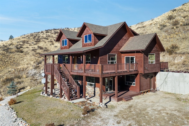 rear view of house with a deck with mountain view